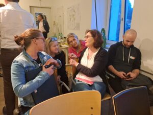 Fünf Personen unterhalten sich bei einem Workshop