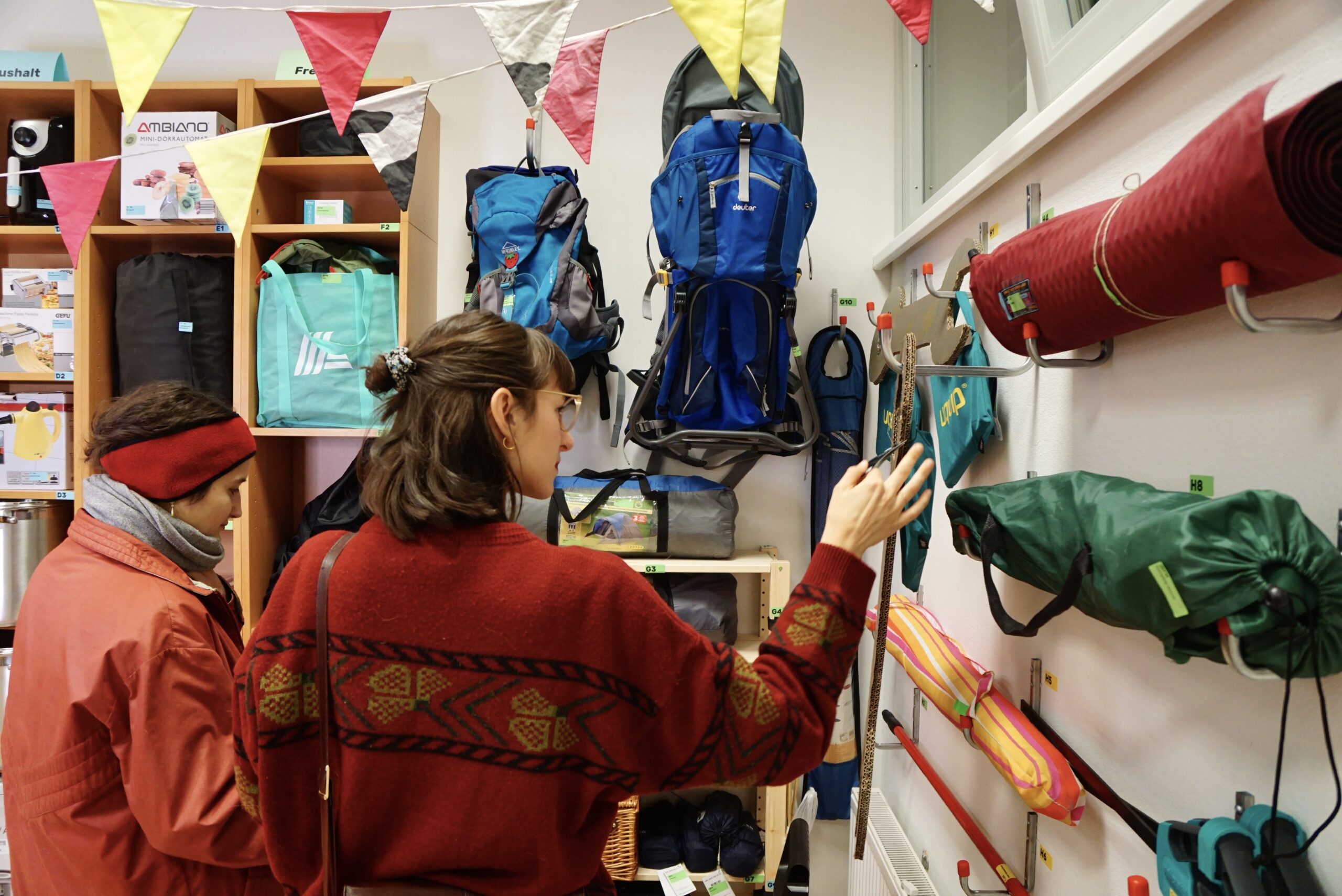 Frau besichtigt Gegenstände im Leihladen des Stadtteilbüros