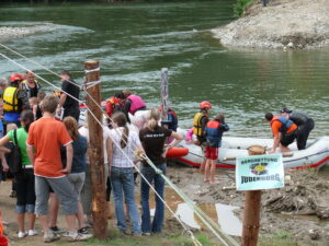 Kinder am Fluss steigen in ein Schlauchboot