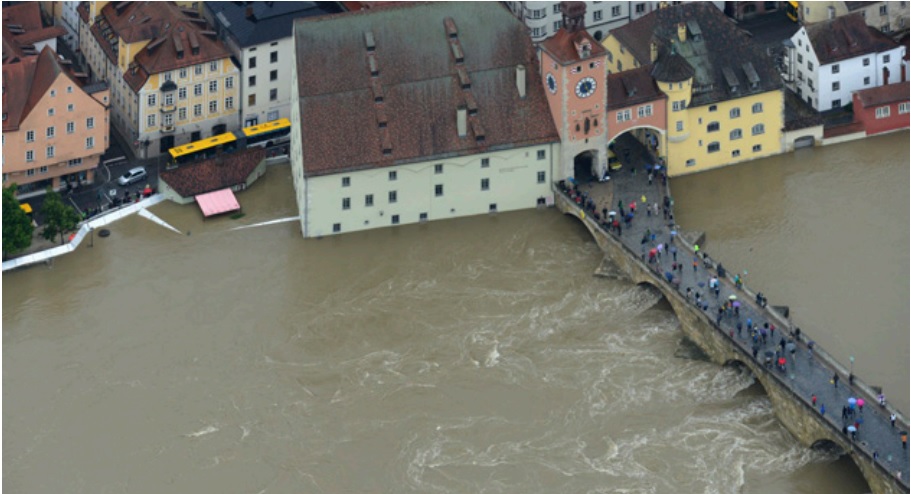 Überschwemmte Straßen in Regensburg, Personen sind auf einer Brücke zu sehen
