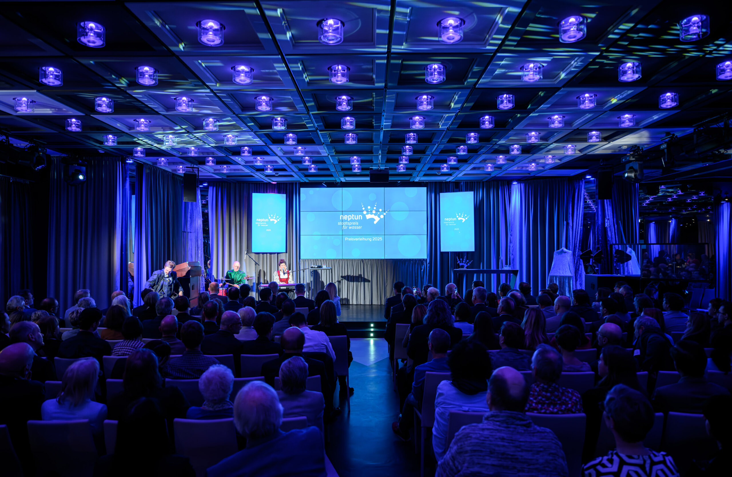 Musikerin Anna Buchinger spielt auf Bühne, Publikum im Saal hört zu