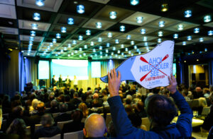 Saal im Palais Berg, Person hebt Schild zu "Ahoi Neusiedler See" hoch