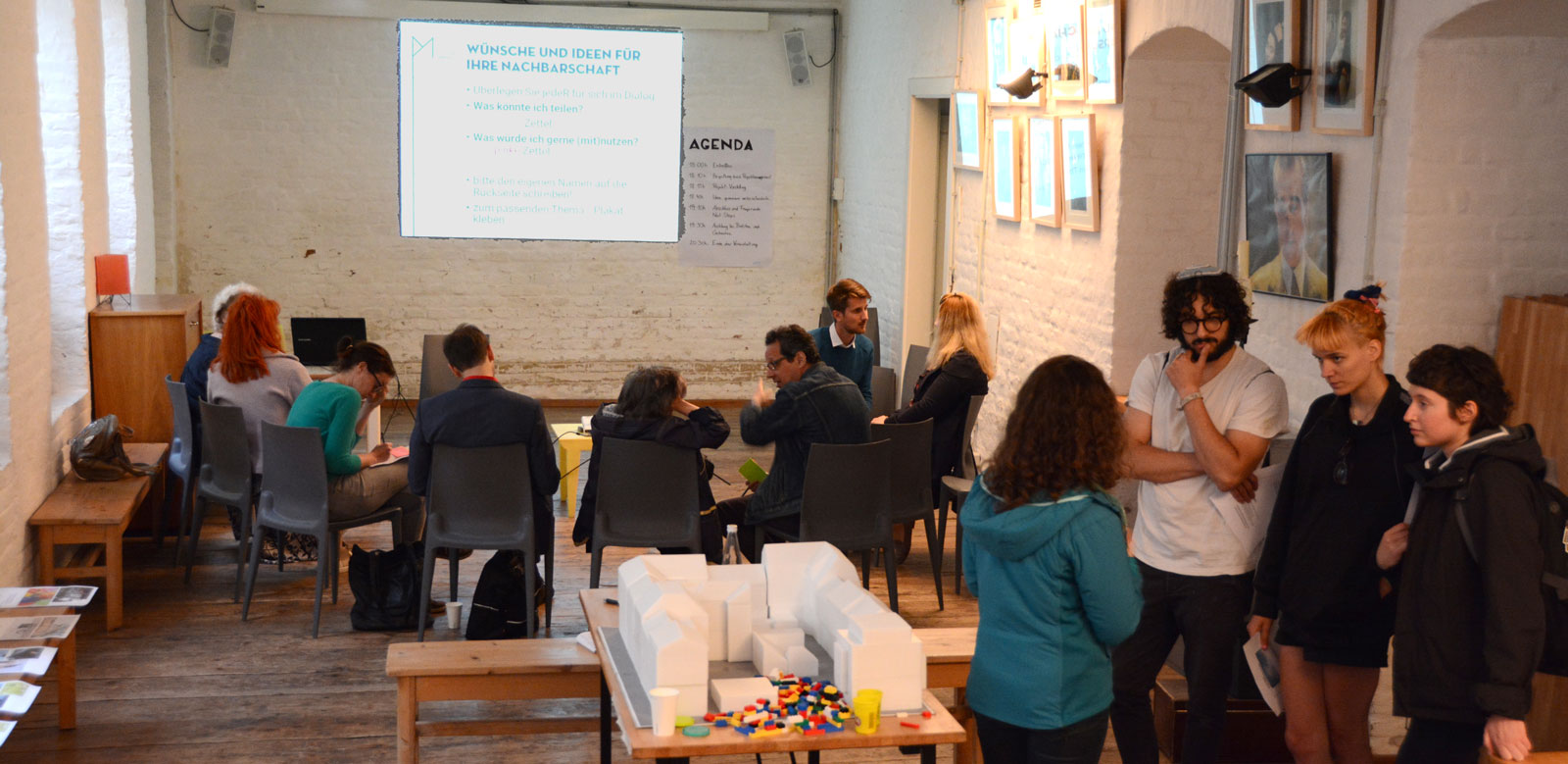 Personen sitzen in Halbkreis und unterhalten sich bei einem Workshop